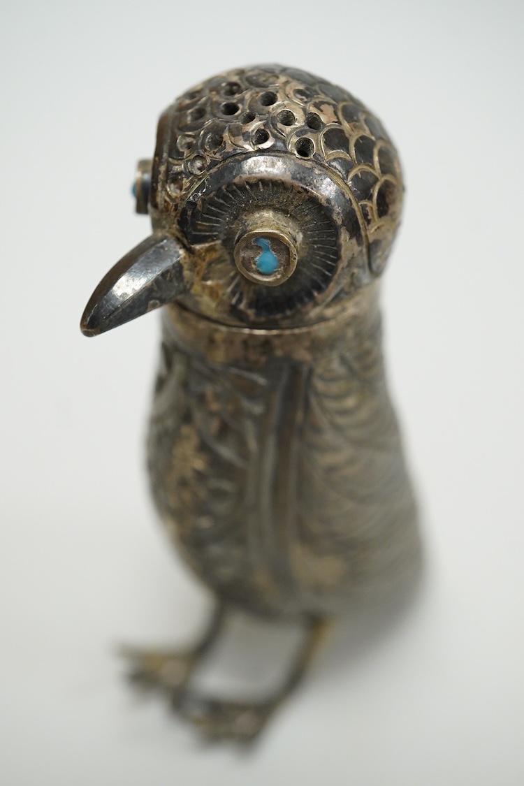 A novelty white metal pepperette, modelled as a free standing bird, with blue glass eyes, indistinct mark to one leg, height 87mm.